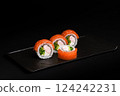 Delicious Fresh Salmon Sushi Rolls Presenting Exquisitely on a Black Background 124242231