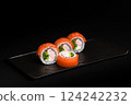 Delicious Fresh Salmon Sushi Rolls Presenting Exquisitely on a Black Background 124242232