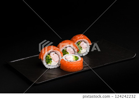 Delicious Fresh Salmon Sushi Rolls Presenting Exquisitely on a Black Background Delicious Fresh Salmon Sushi Rolls Presenting Exquisitely on a Black Background 124242232