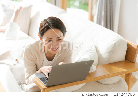 一個女人在沙發上使用電腦 一個女人在沙發上使用電腦 124244799