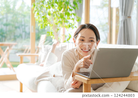 Woman using a computer on the sofa 124244803