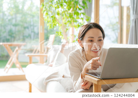 一個女人在沙發上使用電腦 124244804