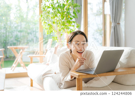 一個女人在沙發上使用電腦 一個女人在沙發上使用電腦 124244806