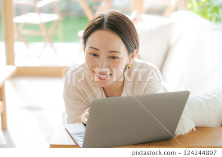Woman using a computer on the sofa Woman using a computer on the sofa 124244807