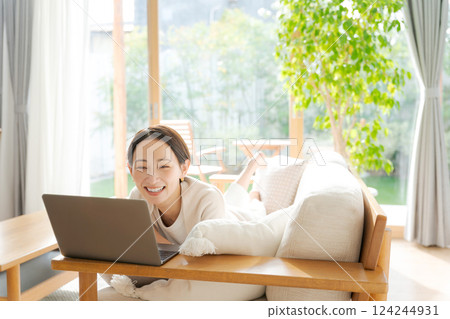 Woman using a computer on the sofa 124244931