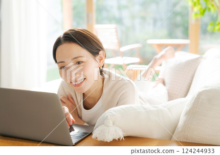 一個女人在沙發上使用電腦 一個女人在沙發上使用電腦 124244933