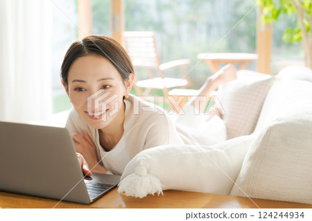 一個女人在沙發上使用電腦 124244934