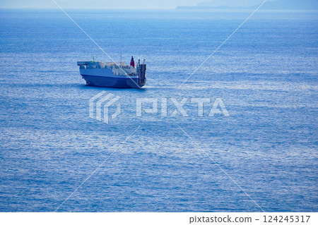 A large cargo ship sailing through the blue Pacific Ocean A large cargo ship sailing through the blue Pacific Ocean 124245317