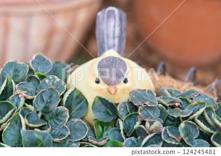 Figurine of a small bird hiding in leaves 124245481