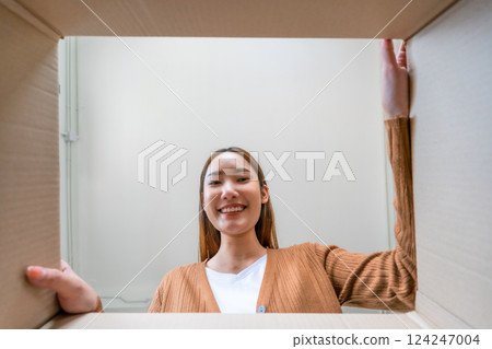 Low angle view of surprised young asian woman unpacking Low angle view of surprised young asian woman unpacking 124247004