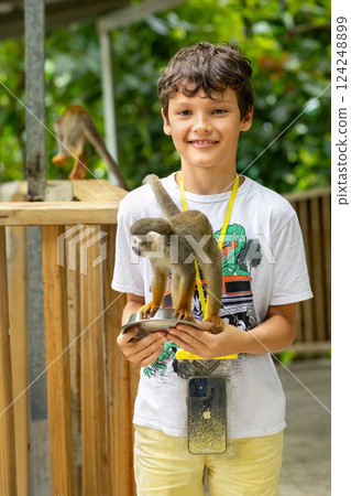 Young traveler is feeding a monkey from hands in the zoo. 124248899