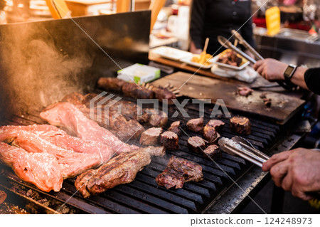 Some excellent pieces of Argentinian beef on a charcoal grill being prepared at open kitchen street food festival in Ljubljana, Slovenia Some excellent pieces of Argentinian beef on a charcoal grill being prepared at open kitchen street food festival in Ljubljana, Slovenia 124248973