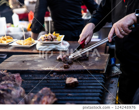 Some excellent pieces of Argentinian beef on a charcoal grill being prepared at open kitchen street food festival in Ljubljana, Slovenia Some excellent pieces of Argentinian beef on a charcoal grill being prepared at open kitchen street food festival in Ljubljana, Slovenia 124248976