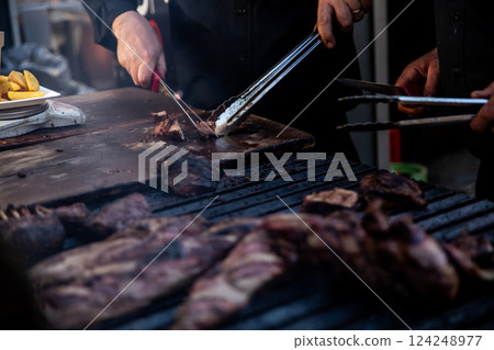 Some excellent pieces of Argentinian beef on a charcoal grill being prepared at open kitchen street food festival in Ljubljana, Slovenia Some excellent pieces of Argentinian beef on a charcoal grill being prepared at open kitchen street food festival in Ljubljana, Slovenia 124248977