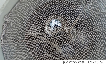 The interior of a tall control tower with the entrance protected by a mesh. 124249152