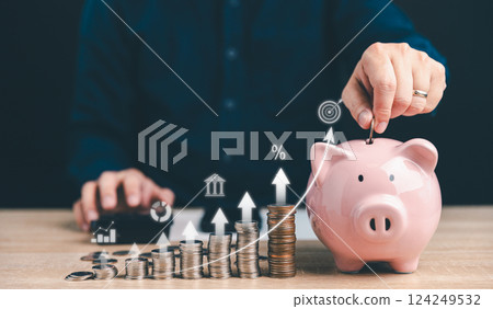Man put money coin into pink piggy bank for saving money wealth, The concept of saving money or investment. Man put money coin into pink piggy bank for saving money wealth, The concept of saving money or investment. 124249532