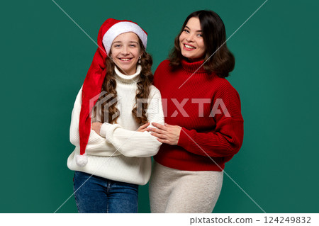 Mum, teenage daughter wearing red and white sweaters, arms linked 124249832