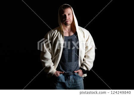 Man in hooded fleece jacket and jeans, hands in pockets. Man in hooded fleece jacket and jeans, hands in pockets. 124249840