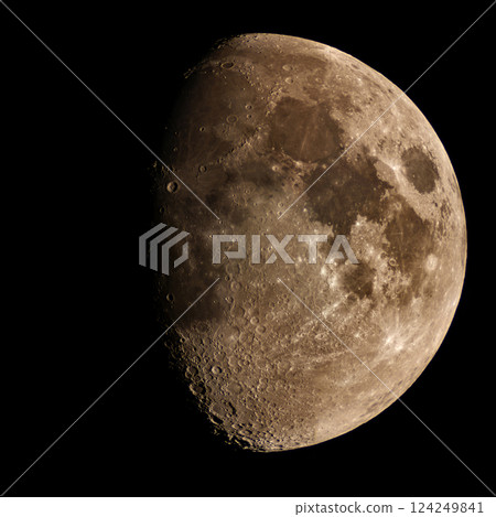Detailed golden gibbous moon revealing craters against dark sky 124249841