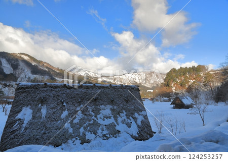 The white snow fields that stand out against the blue sky of the Ogimachi Gassho-style village in Shirakawa-go 124253257
