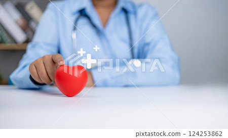 Healthcare worker and doctor service, Doctor showing a red heart and sing plus at hospital office, Medical technology concept, Health insurance concept, Health planning concept. Healthcare worker and doctor service, Doctor showing a red heart and sing plus at hospital office, Medical technology concept, Health insurance concept, Health planning concept. 124253862