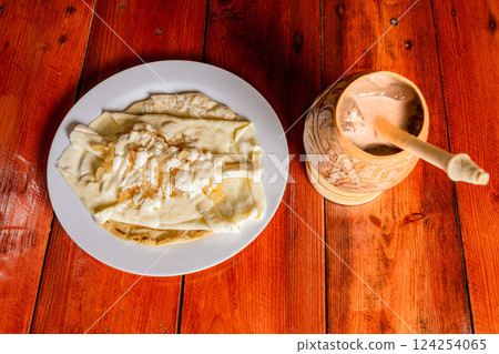 Delicious traditional Quesillo with cocoa drink. Quesillo plate with cocoa drink served on wooden table. Typical Nicaraguan food and drinks. 124254065