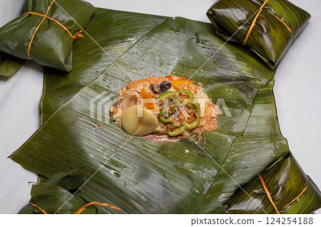 Top View of raw ingredients of the Nicaraguan nacatamal on banana leaves. Raw ingredients for the preparation of the traditional Nacatamal, Nacatamal ingredients on banana leaves Top View of raw ingredients of the Nicaraguan nacatamal on banana leaves. Raw ingredients for the preparation of the traditional Nacatamal, Nacatamal ingredients on banana leaves 124254188