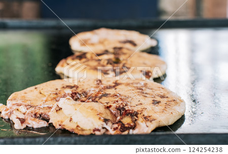 Traditional Nicaraguan pupusas with melted grilled cheese, Traditional cheese pupusas on the grill, Close up of traditional handmade pupusas on the grill. Traditional Nicaraguan pupusas with melted grilled cheese, Traditional cheese pupusas on the grill, Close up of traditional handmade pupusas on the grill. 124254238