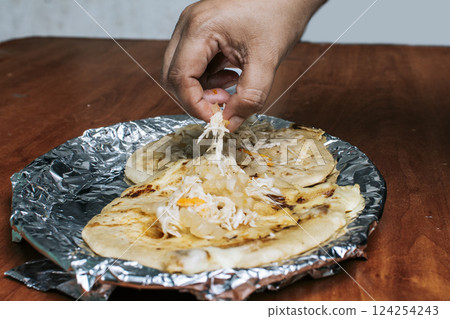 Nicaraguan pupusas with salad on aluminum foil, View of delicious Salvadoran pupusas served on wooden table. Traditional pupusas served with salad on the table Nicaraguan pupusas with salad on aluminum foil, View of delicious Salvadoran pupusas served on wooden table. Traditional pupusas served with salad on the table 124254243
