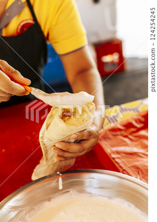 Hands making a Nicaraguan quesillo. Close up of hands making a traditional quesillo with pickled onion. Preparation of Nicaraguan quesillo, traditional Central American food quesillo Hands making a Nicaraguan quesillo. Close up of hands making a traditional quesillo with pickled onion. Preparation of Nicaraguan quesillo, traditional Central American food quesillo 124254245