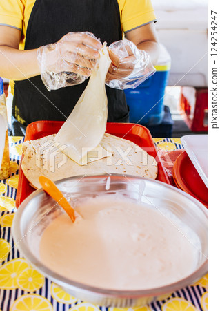 Preparation of Nicaraguan QUESILLO, traditional Central American food quesillo. Hands making a Nicaraguan quesillo. Close up of hands making a traditional quesillo with pickled onion. Preparation of Nicaraguan QUESILLO, traditional Central American food quesillo. Hands making a Nicaraguan quesillo. Close up of hands making a traditional quesillo with pickled onion. 124254247