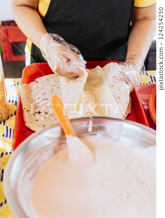 Homemade Nicaraguan Quesillo, traditional Central American food quesillo. Hands making a Nicaraguan quesillo. Close up of hands making a traditional quesillo with pickled onion. Homemade Nicaraguan Quesillo, traditional Central American food quesillo. Hands making a Nicaraguan quesillo. Close up of hands making a traditional quesillo with pickled onion. 124254250