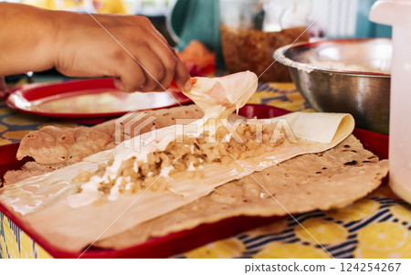 Hands making Nicaraguan Quesillo. Central American food the Quesillo, View of the traditional Quesillo with pickled onion, Preparation of the Traditional Nicaraguan Quesillo Hands making Nicaraguan Quesillo. Central American food the Quesillo, View of the traditional Quesillo with pickled onion, Preparation of the Traditional Nicaraguan Quesillo 124254267