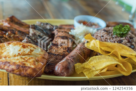 Variety of fried and grilled meats served on wooden table. Traditional Nicaraguan bay horse served on the table. Variety of food meats and assortment of sausages Variety of fried and grilled meats served on wooden table. Traditional Nicaraguan bay horse served on the table. Variety of food meats and assortment of sausages 124254356