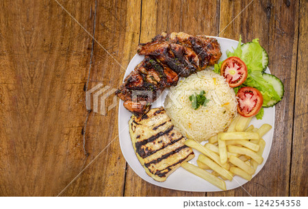 Top view of plate of fresh Pork rib served on the table. Pork rib with rice, fried cheese and salad served on the table, Close up of Pork rib with salad and French fries served on wooden table 124254358