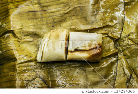 Traditional tamale served in banana leaves. Top view of a traditional tamale on a banana leaf. Nicaraguan pisque tamale on banana leaf. Tamalpisque traditional Central American food Traditional tamale served in banana leaves. Top view of a traditional tamale on a banana leaf. Nicaraguan pisque tamale on banana leaf. Tamalpisque traditional Central American food 124254366