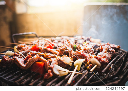 Charcoal roasted meat skewers. Homemade roast meat skewers on charcoal grill. Top view of meat roasted on a grill 124254397