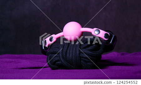 Bdsm outfit. Bondage and Gag ball on the purple bedsheet. Adult sex games. Kinky lifestyle. Bdsm outfit. Bondage and Gag ball on the purple bedsheet. Adult sex games. Kinky lifestyle. 124254552