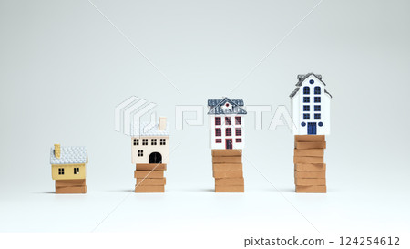 Tiny houses stacked on bricks symbolize rising property prices 124254612