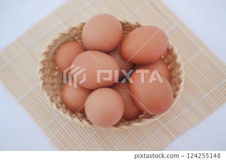 a woven basket filled with fresh brown eggs a woven basket filled with fresh brown eggs 124255148
