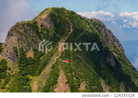 A rescue helicopter and the Yatsugatake mountain range and Amida-dake seen from the traverse route from the Kirito 124255326