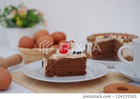 a slice of chocolate cake placed on a white plate a slice of chocolate cake placed on a white plate 124255583