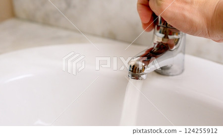 Hand opening water faucet, showing saving water concept Hand opening water faucet, showing saving water concept 124255912