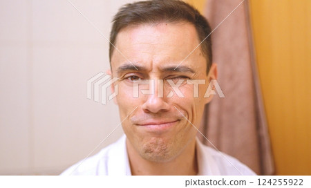 Hispanic man winking and smiling in bathroom, getting ready 124255922