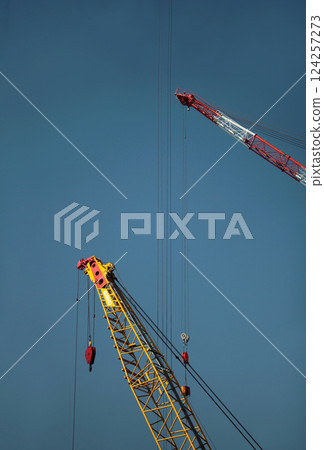 藍天白雲下，大型起重機正在工作 124257273