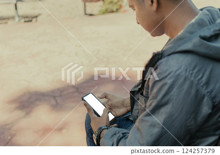 Close up of a man with cell phone in hand, close up shot of a person checking his cell phone, young guy with cell phone in hand with copy space Close up of a man with cell phone in hand, close up shot of a person checking his cell phone, young guy with cell phone in hand with copy space 124257379