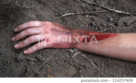 Hand of a wounded soldier on the ground Hand of a wounded soldier on the ground 124257409