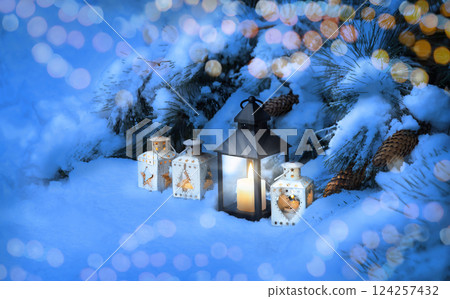 Lanterns in the snow under the Christmas tree Lanterns in the snow under the Christmas tree 124257432