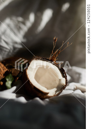 Fresh coconuts on a white cloth with one halved coconut revealing its inner flesh Fresh coconuts on a white cloth with one halved coconut revealing its inner flesh 124258031