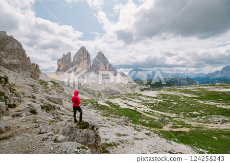 Hiker admires Tre Cime di Lavaredo, Dolomites. 124258243